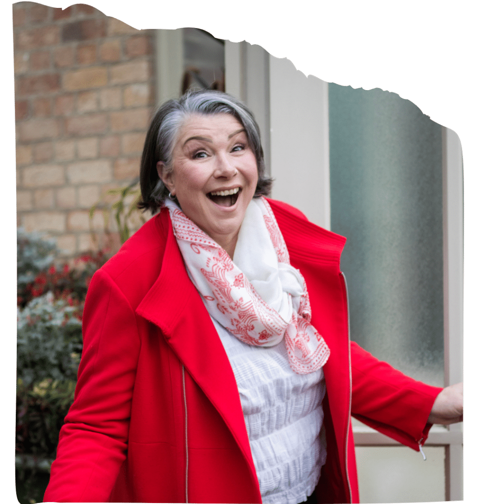 Stephanie Wium, Canva designer behind the I’m Not Doing This Myself Launch Kit, smiling in a bright red coat.